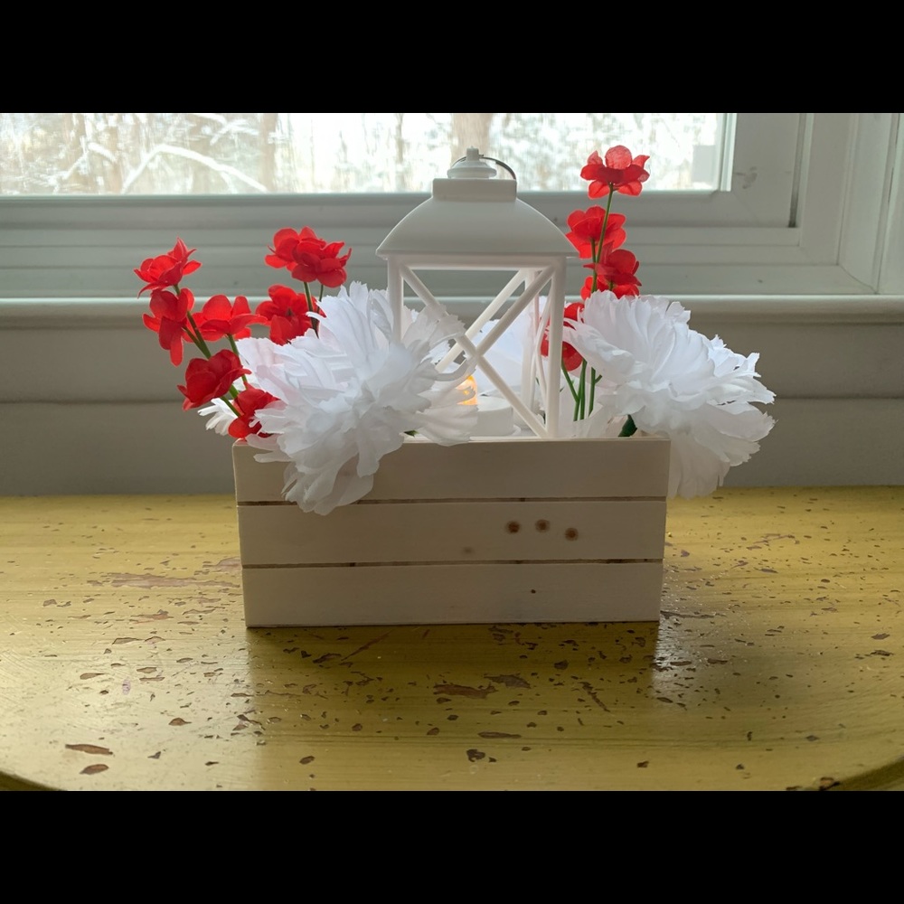 Crate and lantern centerpiece with red flowers